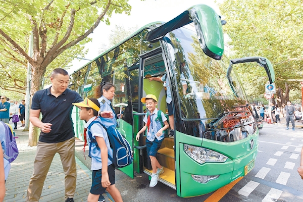 9月1日，北京首批25条通学公交车线路投入试运行。在丰台一小校门前，首批体验的小学生乘着绿色的通学公交车来到学校。
